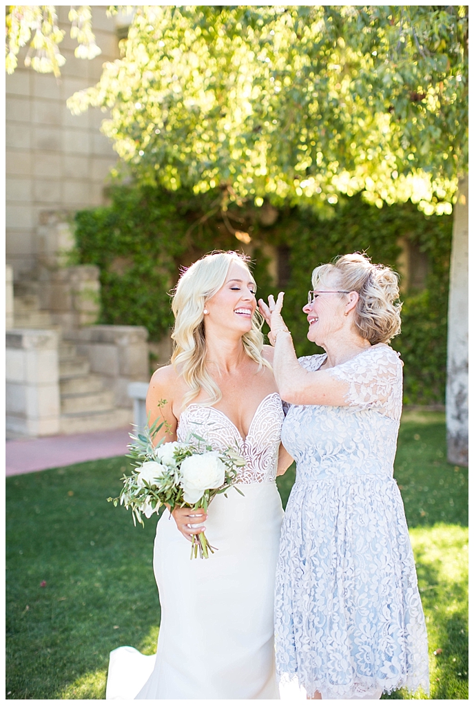 bride in two piece wedding dress with white floral bouquet with mother