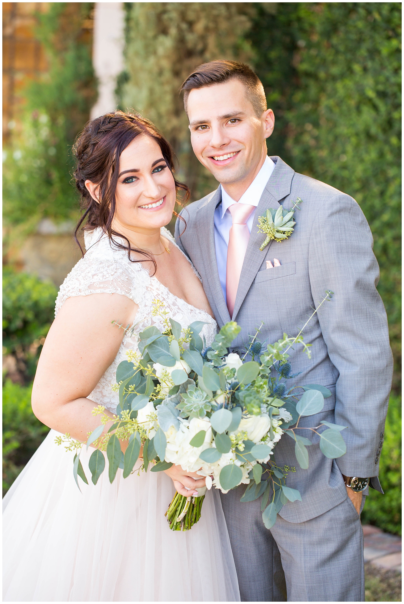 Bride in sleeved white dress and groom in gray jacket