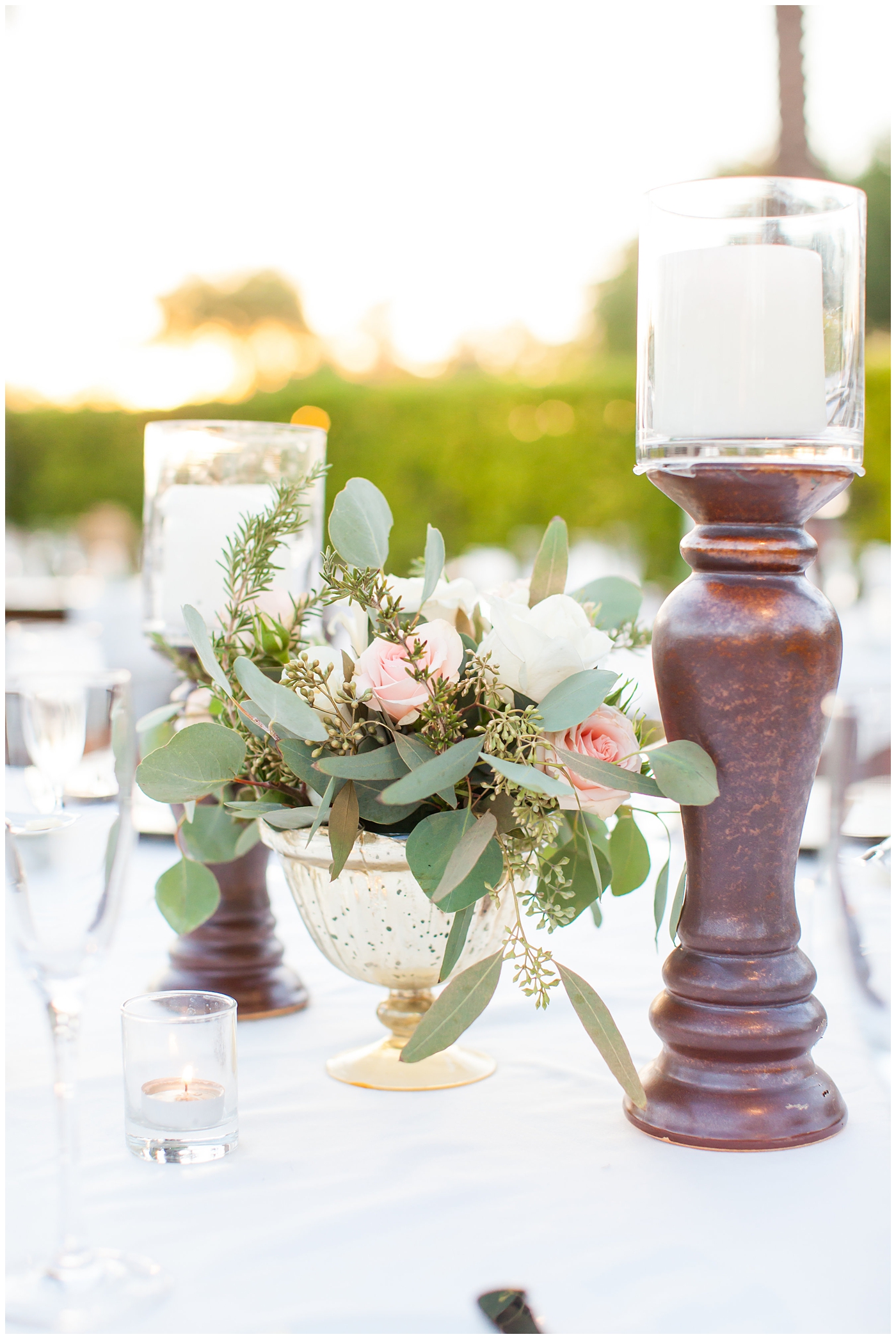 wedding reception table centerpiece with pink roses and greenery