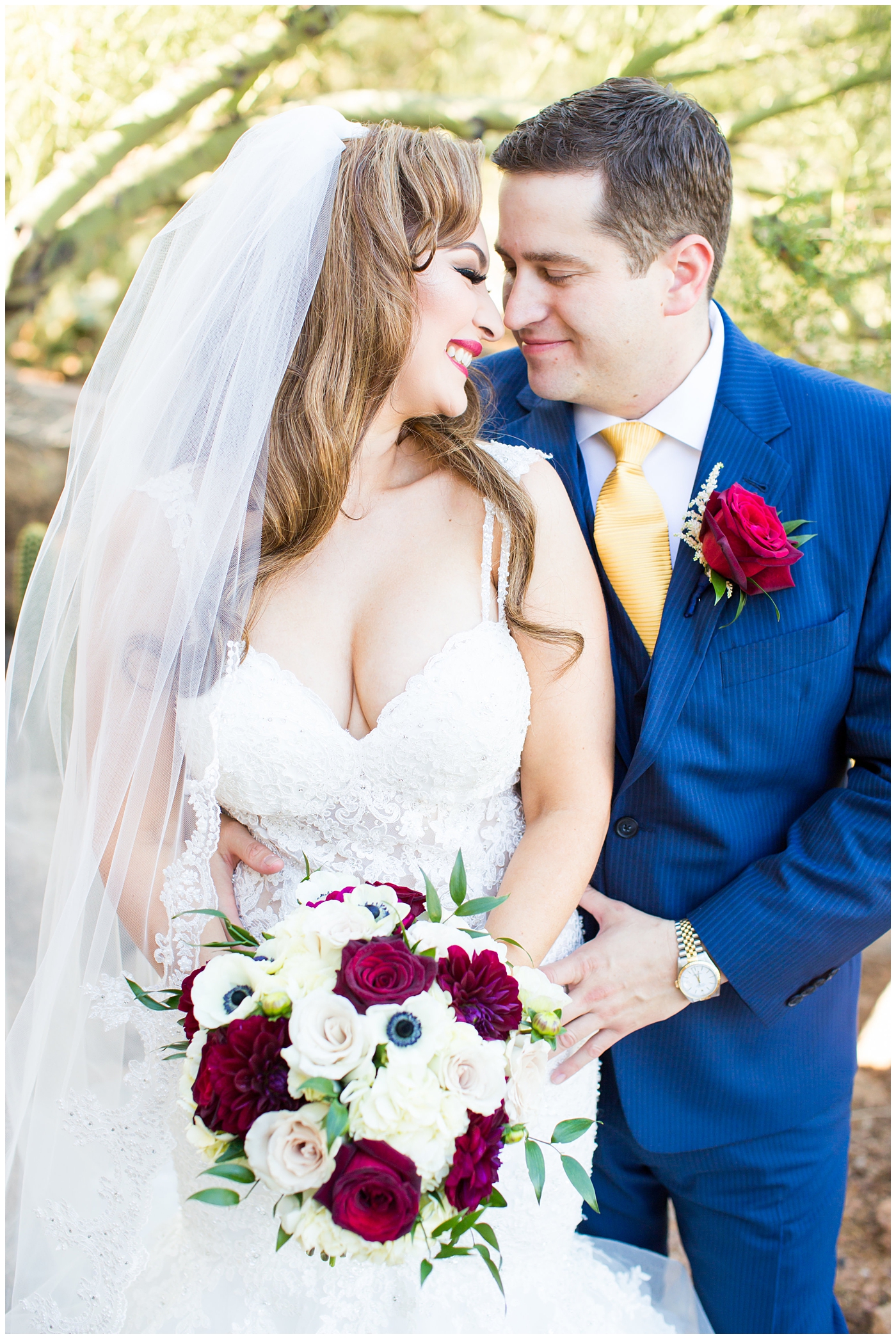groom in blue suit with yellow tie and red rose boutonniere and bride in morilee wedding dress with red and white bouquet portrait
