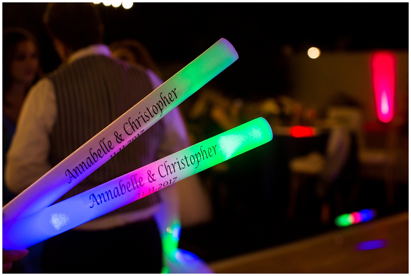 light up rave sticks for wedding reception guests dancing at outdoor wedding reception with twinkle lights strung above