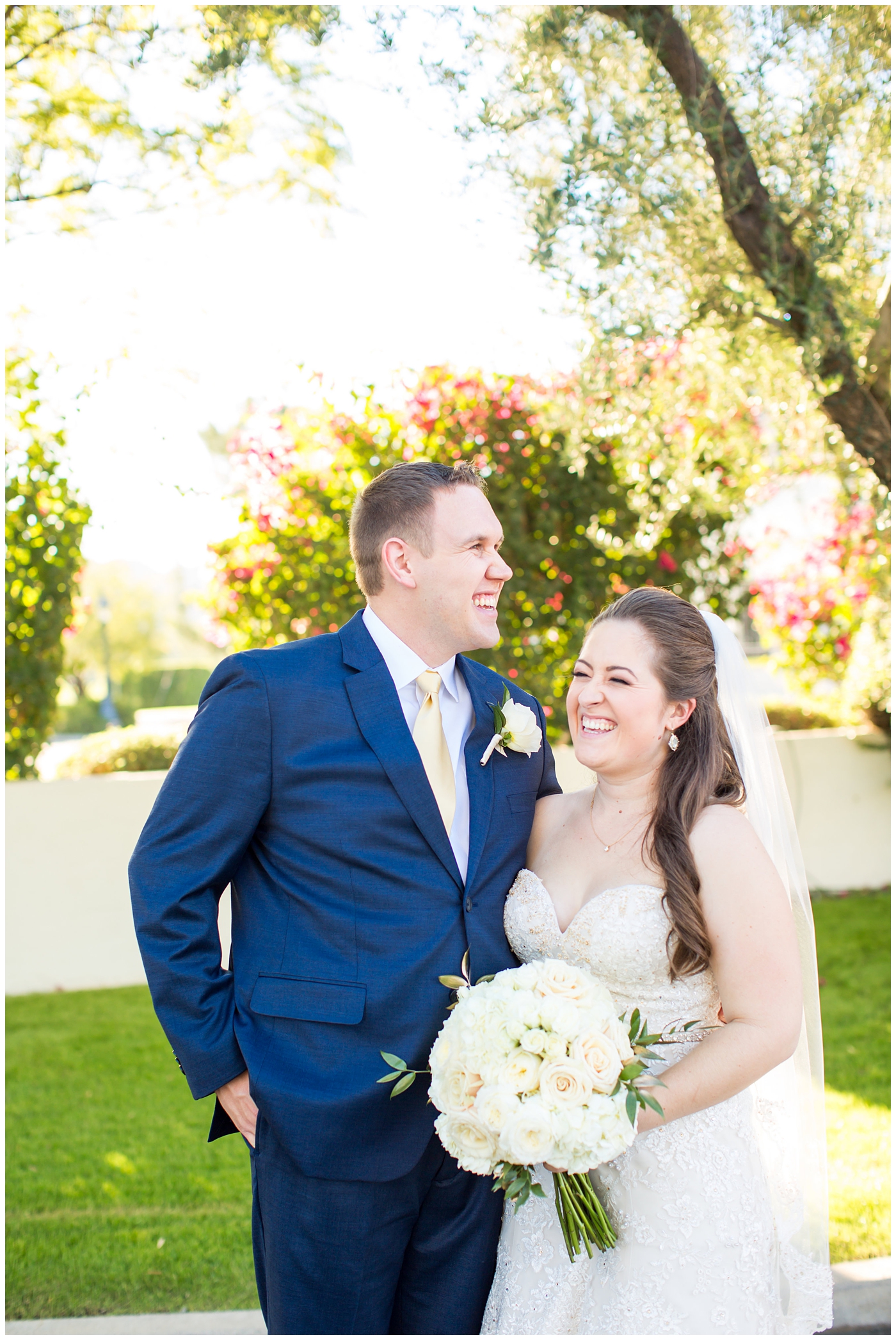 bride in lillian lottie couture wedding dress with white rose bouquet and groom in navy blue suit from men's warehouse bride and groom wedding portrait