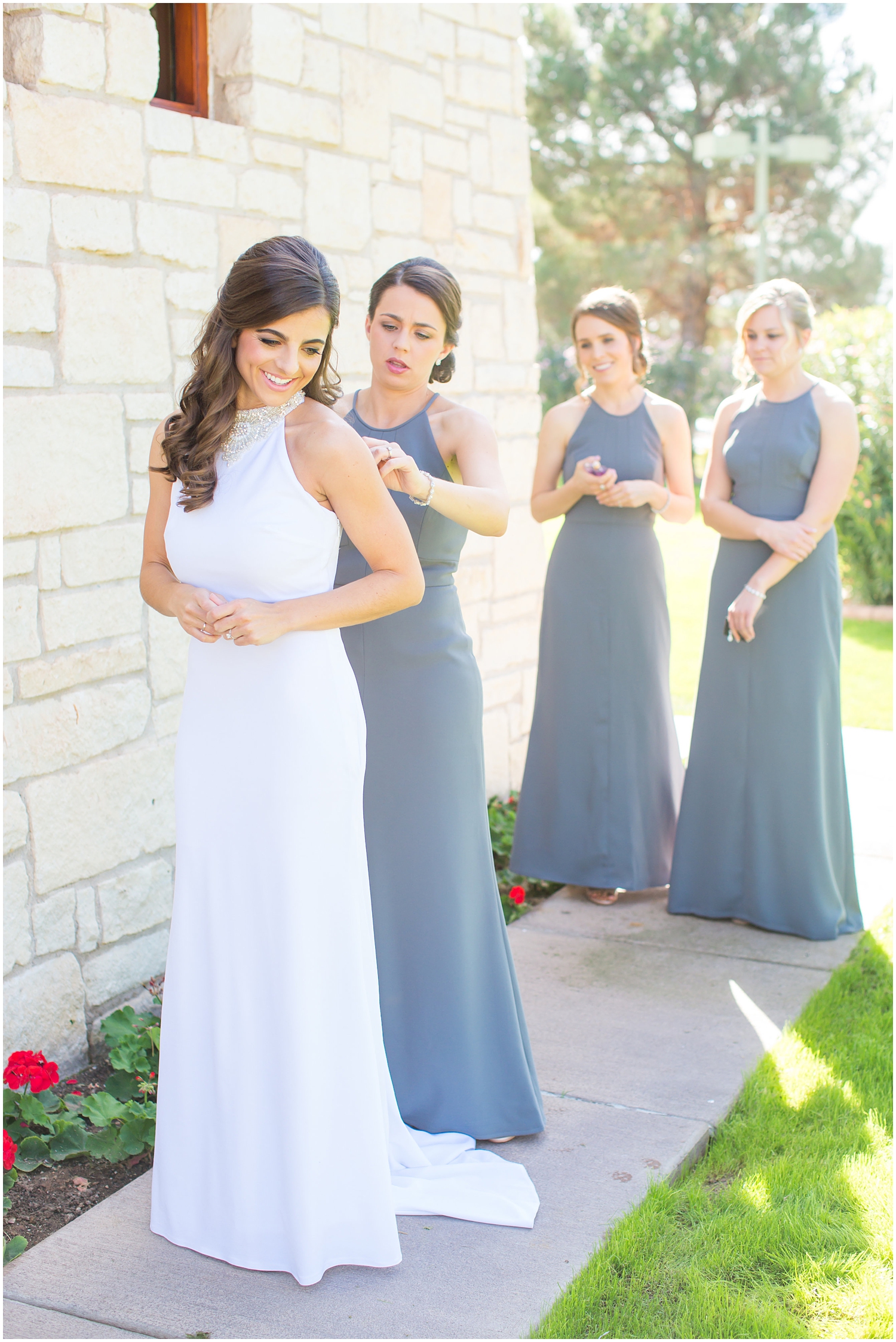 bride in demetrios bridal gown racerback with sheer beading with bridesmaids in gray dresses getting ready