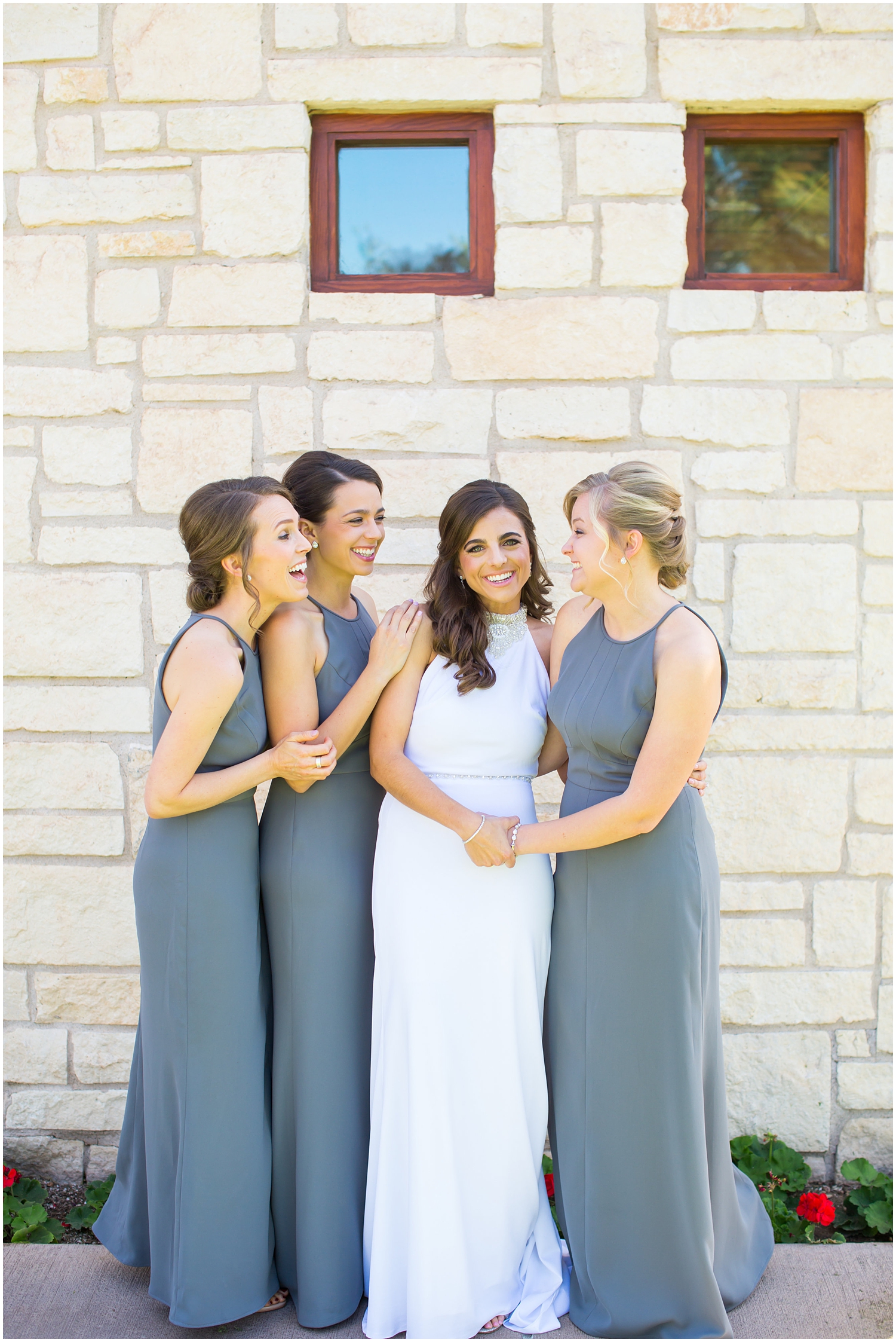 bride in demetrios bridal gown racerback with sheer beading with bridesmaids in gray dresses getting ready