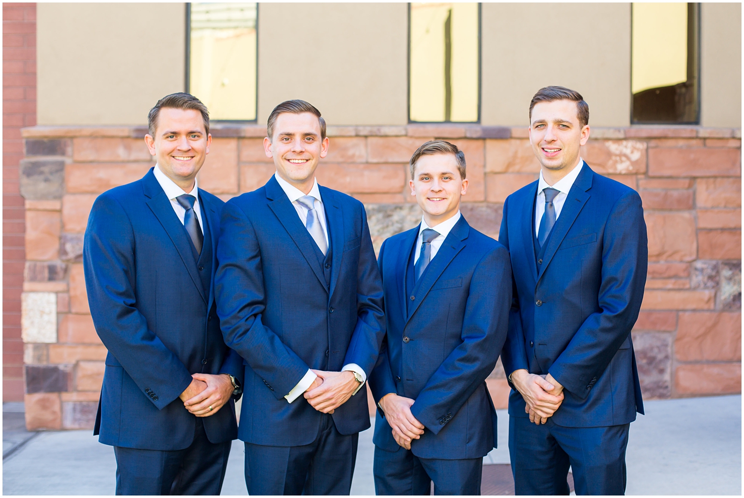 groom and groomsmen in navy blue suit with light blue tie getting ready on wedding day