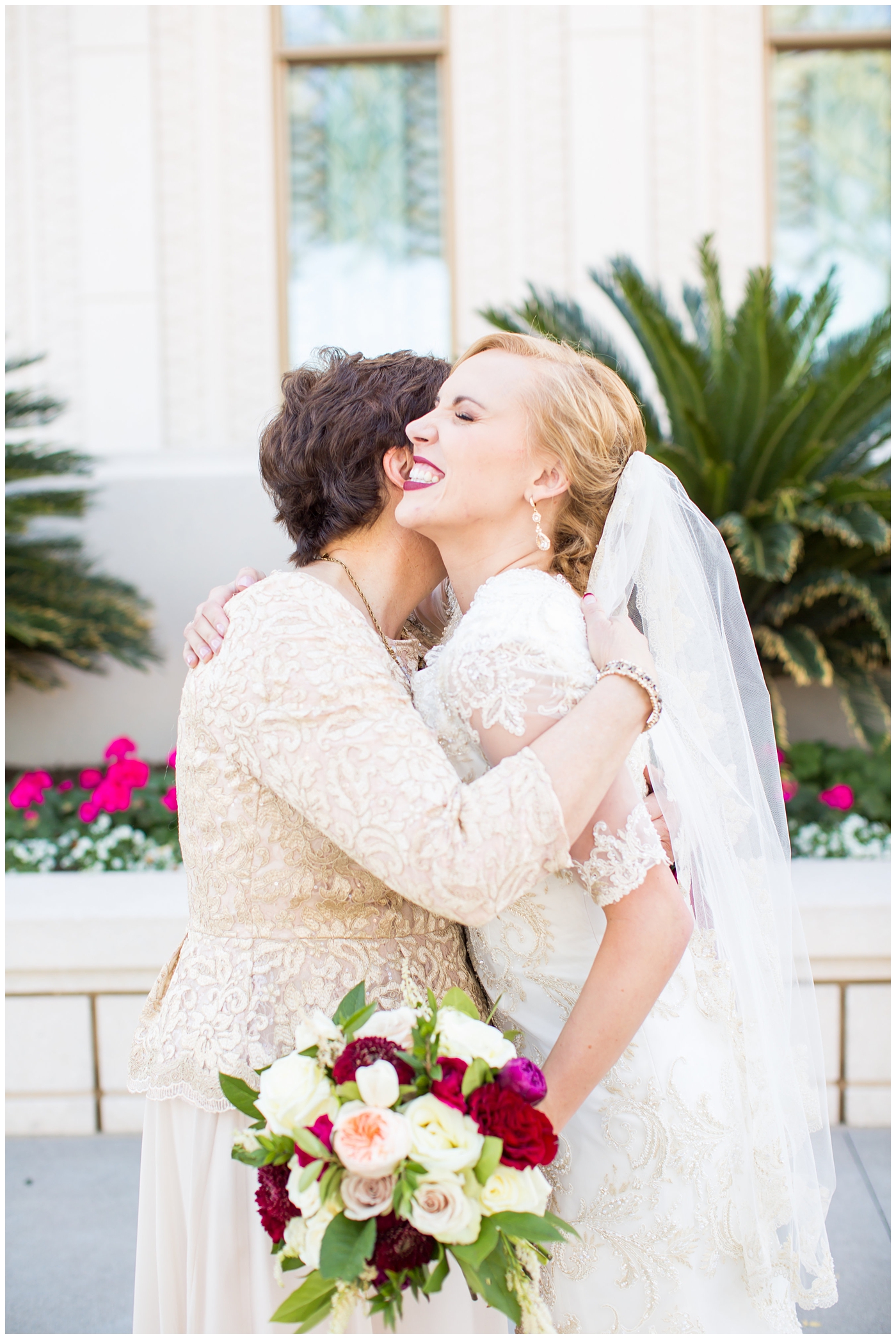 bride in sleeved lace dress with burgundy, white, and green wedding bouquet wedding day portrait with mother at Gilbert LDS temple