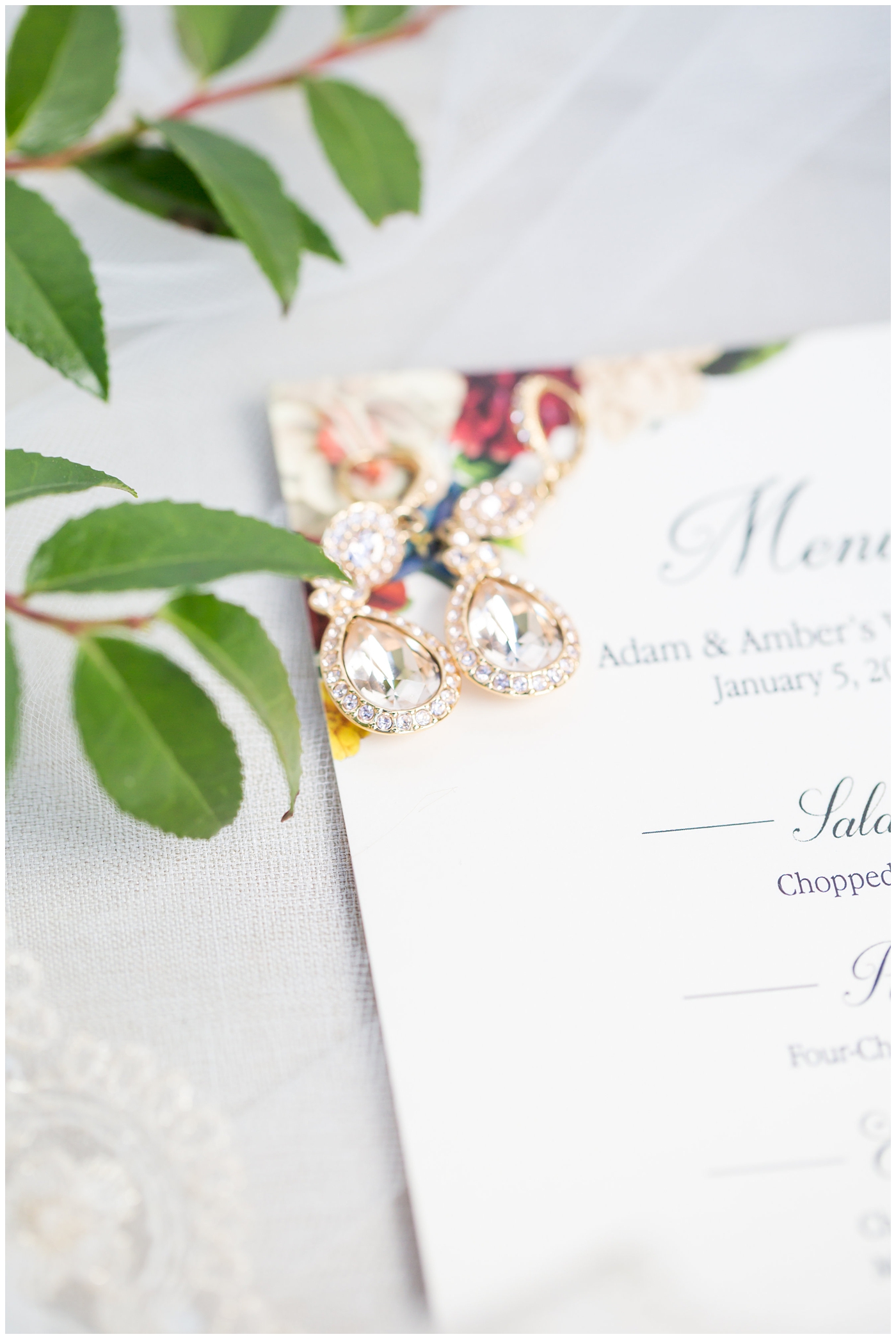wedding invite with burgundy florals with rose gold wedding rings and bands wedding day details