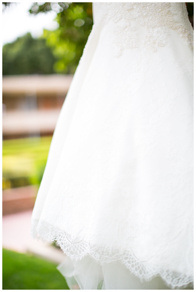 Matthew Christopher wedding dress with cap sleeves hanging on tree at Arizona Biltmore