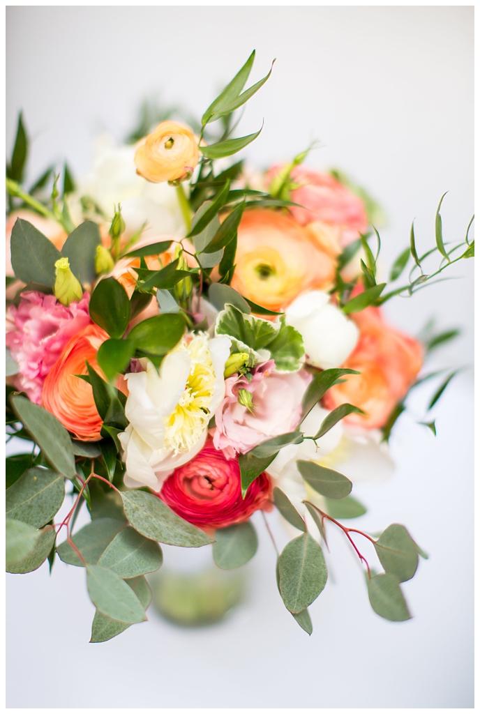 white, pink and orange ranunculus flowers and greenery bouquet wedding day