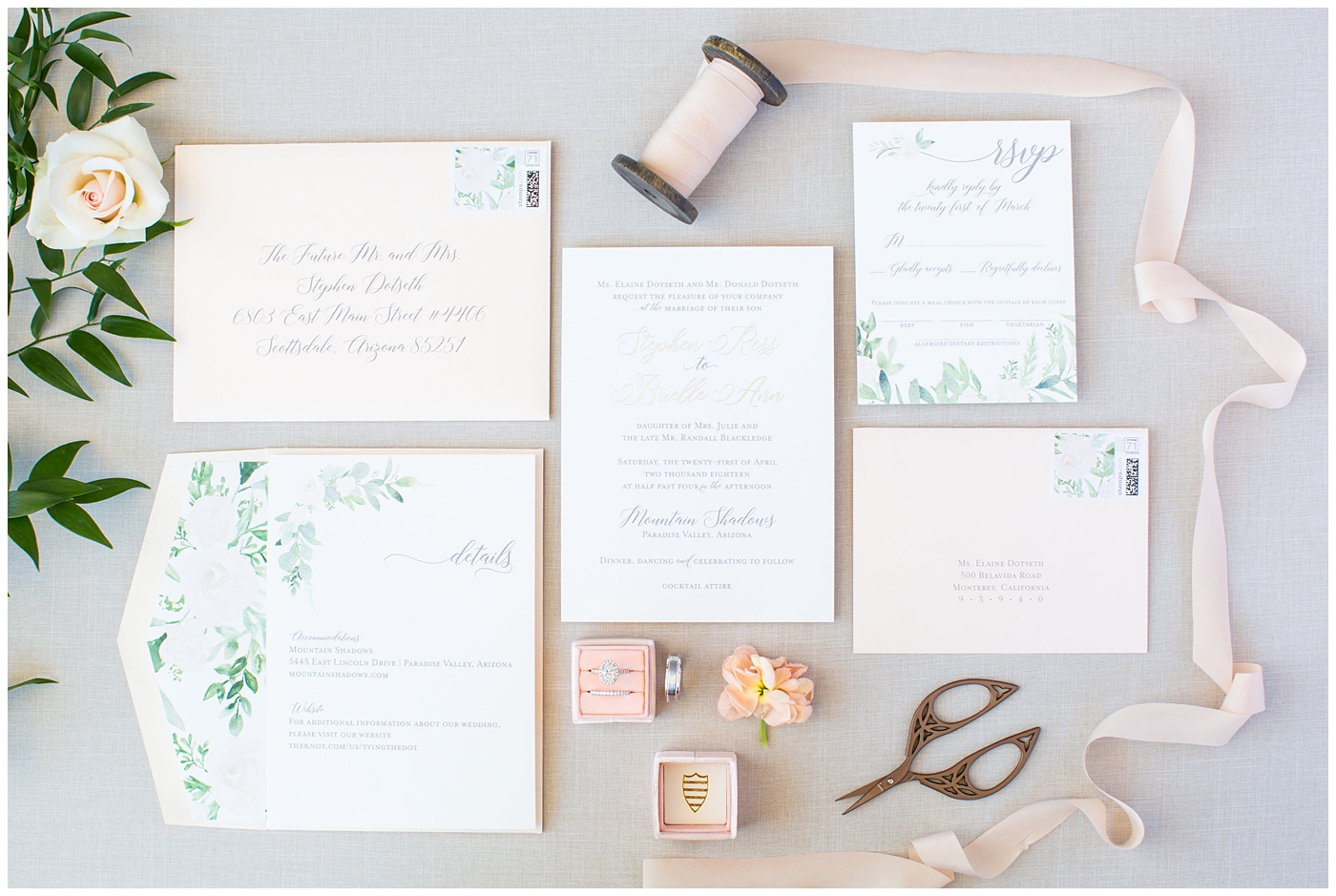blush pink invitation with soft green watercolor suite detail flat lay with ribbon and rings wedding details