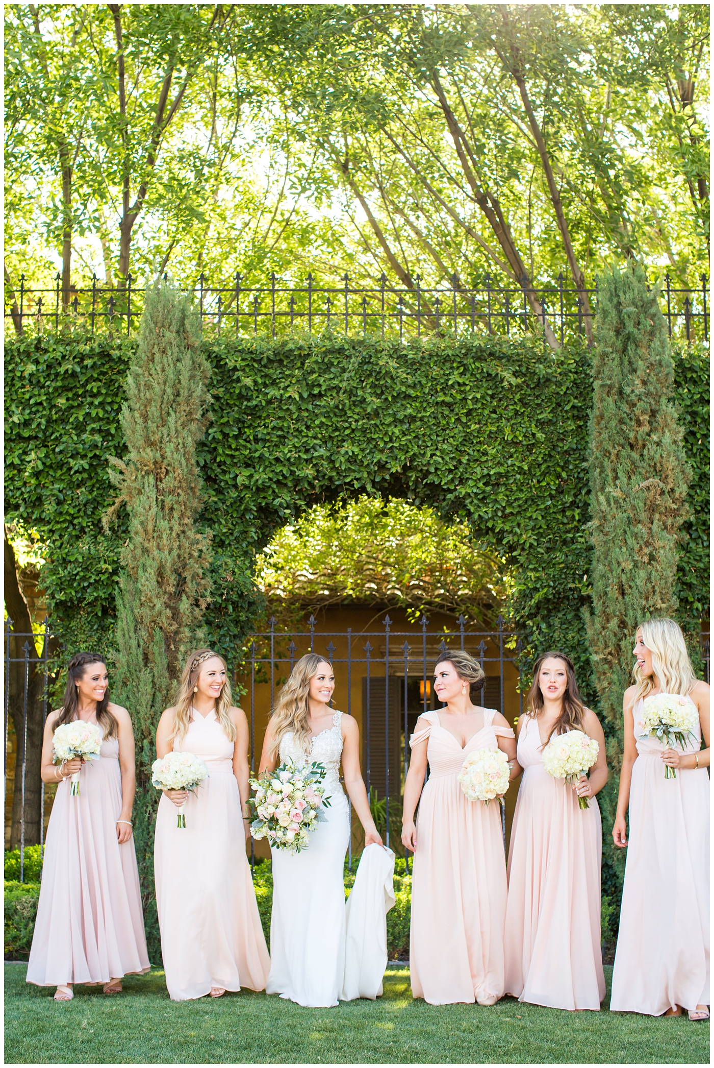 bride in lillian lottie couture strapped beaded wedding dress with bridesmaids in long blush dresses on wedding day portrait