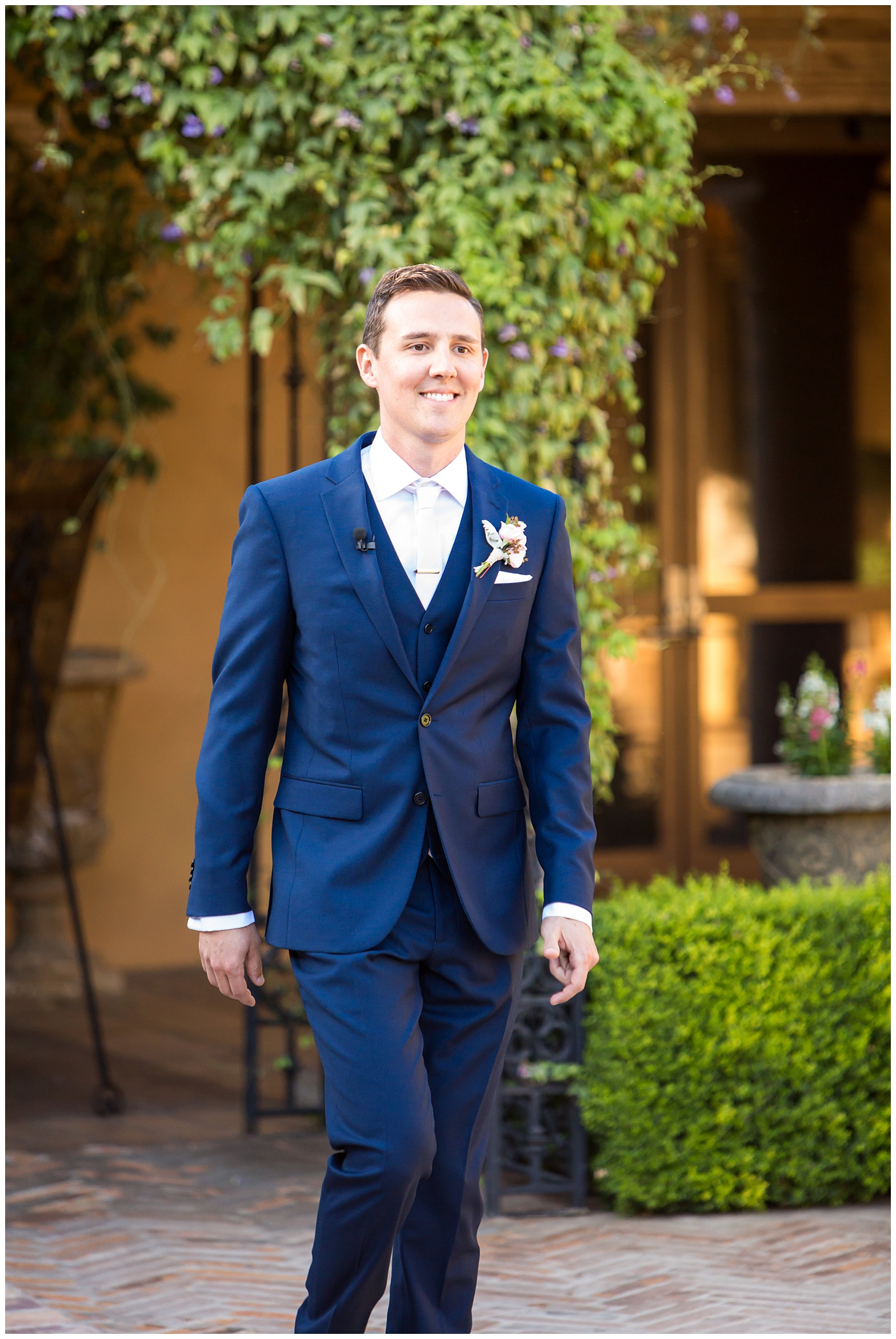 groom in blue suit walking down aisle at wedding ceremony